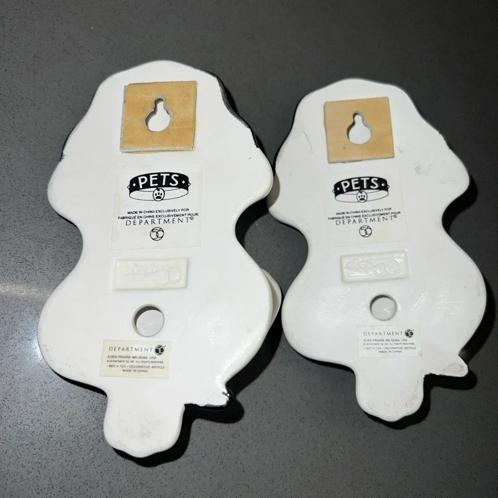 Two black-and-white dog wall hooks